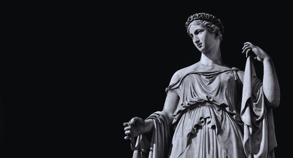 Statue antique de déesse drapée en marbre sur fond noir